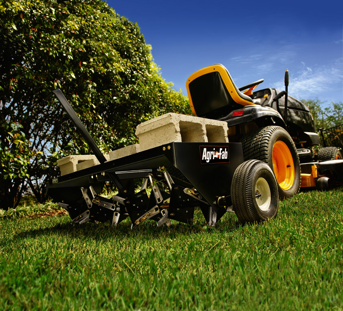 Core aerator removing soil plugs from a lawn